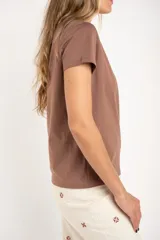 Remera de algodón peinado color blanco, con escote en V y detalles de lurex dorado en el borde del escote. De manga corta y corte ajustado.