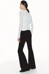 Leggings de punto color negro, de tiro alto con elástico oculto en la cintura y piernas acampanadas.