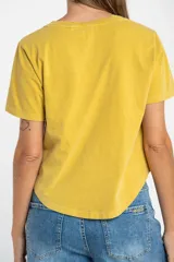 Remera oversize de algodón lavado color mostaza, de manga corta y cuello redondo. Presenta un pequeño bordado en forma de estrella en la parte inferior.