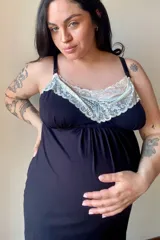 Camisón maternal de modal gris con detalle de puntilla blanca en el escote. Presenta breteles regulables con clip para lactancia y un diseño holgado pensado para la etapa de gestación.