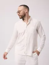 Camisa blanca de lino y poliéster, de manga larga con cuello abotonado y bolsillo en el pecho.