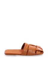 Sandalias mule chatas de cuero color suela, con capellada trenzada y plantilla forrada. Modelo de punta cuadrada.