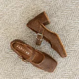 Zapato estilo Mary Jane de cuero vacuno con acabado brillante, punta cuadrada y taco bloque. Cuenta con una tira ajustable sobre el empeine con hebilla metálica.