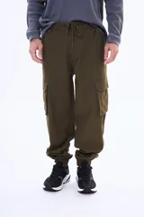 Pantalon cargo de gabardina en color verde militar, con bolsillos laterales con solapa, cintura elastizada con cordón de ajuste y puños elastizados en los tobillos.