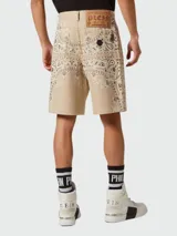 Bermuda de mezclilla color beige con estampado paisley en tonos marrón y blanco.