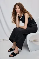 Falda larga de denim negro con diseño a rayas verticales y calce recto, tiro medio, bolsillos y cierre con botón.