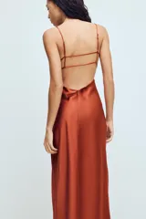 Vestido midi de tejido satinado color terracota, con escote en pico, tirantes finos ajustables y espalda con tiras cruzadas.