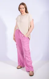 Pantalón de lino color lila, de corte ancho y tiro medio, con bolsillos laterales y cintura elastizada con cordón ajustable.