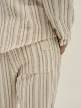 Camisa de manga larga con cuello tipo Mao, a rayas verticales color beige y blanco.