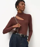 Blusa de punto acanalado color marrón, con cuello alto y diseño de manga larga. Presenta una abertura tipo cutout en uno de los hombros y un ajuste al cuerpo.