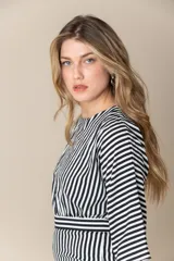 Mono largo a rayas verticales blancas y negras con mangas cortas asimétricas y cierre invisible en la espalda.