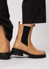 Bota de cuero color camel, estilo Chelsea, con elásticos laterales negros y suela track negra.