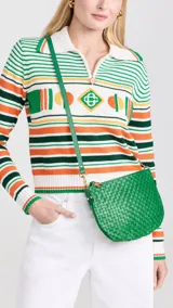 Bandolera verde de cuero tejido con correa de hombro ajustable y cierre de cremallera.