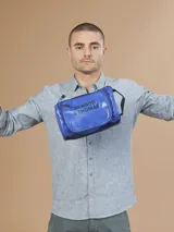 Neceser azul con cierre superior y correa de mano. Estampado con el logo "Benson & Thomas" en el frente.