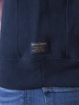 Buzo de frisa azul marino con cuello alto y cierre metálico azul.