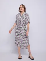 Vestido camisero midi azul con estampado floral blanco, corte recto, cuello camisero, mangas cortas, bolsillos laterales y lazo ajustable en la cintura.