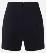 Short pollera corto de tiro alto, confeccionado en bengalina, con diseño de recorte delantero y cierre invisible en la parte posterior.