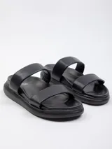 Sandalia baja con plataforma de 2 cm, presenta dos tiras anchas blancas sobre la capellada y base de color negro.