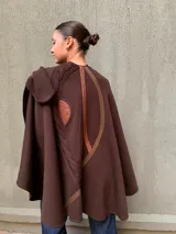 Capa marrón de lana merino con apliques de cuero y tejido de punto trenzado.