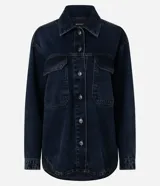 Campera tipo overshirt de denim en color azul oscuro, con corte amplio y largo extendido. Presenta cuello clásico, cierre frontal con botones metálicos, mangas largas y dos bolsillos delanteros con solapa.