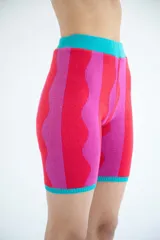 Short biker tejido de punto con diseño a rayas verticales en colores rosa y rojo, con cintura y ruedo en color turquesa.