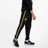 Pantalón de jogging negro con puños elásticos, cordón ajustable en la cintura, escudo del Club Atlético Peñarol bordado en amarillo y franjas laterales amarillas y grises.