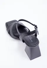 Sandalia alta de símil cuero negro con taco geométrico de 7.5 cm. Posee tiras cruzadas en el empeine con diseño pespuntado y tira ajustable con hebilla en el tobillo.
