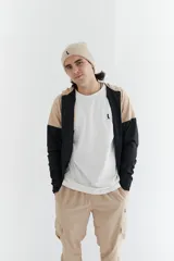 Campera de nylon anti-lluvia con capucha, combinación de colores beige y negro.