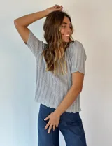 Top de lurex color naranja, con cuello en V y mangas cortas.