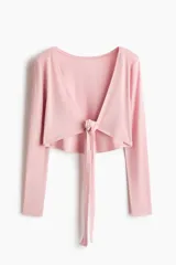 Top cropped de yoga de punto modal suave en color rosado, con mangas largas, escote en V pronunciado y diseño cruzado con tira para anudar al frente.