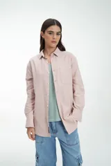 Camisa manga larga color rosa claro, con cuello clásico, cierre frontal con botones, bolsillo en el pecho y corte recto.