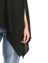 Poncho tejido de punto con diseño asimétrico y aberturas laterales para los brazos.