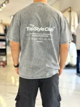 Remera oversize gris con efecto acid wash, de mangas cortas y cuello redondo, con estampado tipográfico blanco en la espalda.