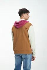 Canguro con capucha, cierre parcial con cremallera, mangas largas y bolsillos laterales. Diseño color block en negro, verde y blanco.