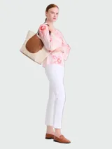 Bolso tote XL Longchamp modelo Complice, confeccionado en lona color crudo con detalles de cuero marrón en las asas y en un bolsillo frontal semicircular.