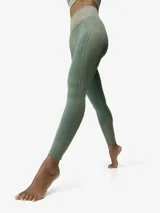 Legging deportivo largo de tiro alto con tecnología seamless 3D y efecto moldeador. Presenta un diseño bicolor que combina texturas de punto liso y canalé, con líneas laterales decorativas que estilizan la figura.