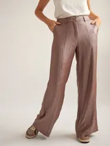 Pantalon de vestir de corte recto y tiro medio-alto, confeccionado en crepe con acabado metalizado lurex. Presenta pretina con detalle de sesgo a contratono, cierre frontal y bolsillos laterales.
