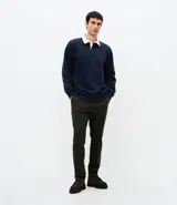 Pantalón slim de sarga lavada color verde militar, de corte ajustado, con trabillas para cinto, bolsillos y cierre frontal con botón y cremallera.