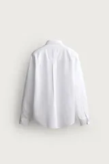 Camisa regular fit de manga larga con diseño a rayas verticales celestes y blancas. Cuenta con cuello abotonado, bolsillo de parche en el pecho y cierre frontal con botones.