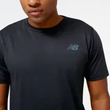 Remera deportiva New Balance Tenacity de hombre, color negro jaspeado, con logo estampado en el pecho. Confeccionada con tejido de poliéster suave y elástico con tecnología NB DRY de secado rápido.