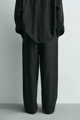 Pantalón de corte relajado confeccionado en una mezcla de lino y viscosa. Presenta bolsillos delanteros, bolsillos traseros de plastrón y cierre frontal con cremallera y botón.