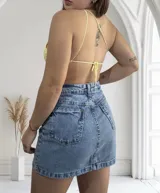 Top tejido al crochet color amarillo, con tirante fino y corte irregular.