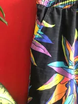 Short de baño Reef negro con estampado de flores abstractas en tonos violeta, naranja, amarillo y celeste.