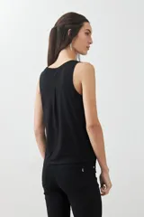 Musculosa verde con escote redondo a la base y sisas anchas.