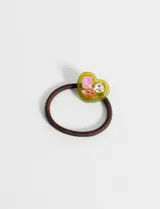 Gomita de pelo marrón con adorno de resina en forma de corazón color verde y apliques de strass.