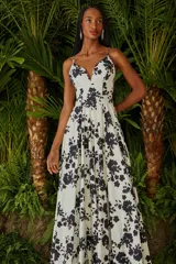 Vestido largo de fiesta color blanco con estampado de flores negras, escote en V y breteles finos.