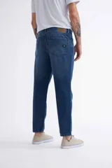 Jean azul oscuro de corte recto, tiro medio y largo a la altura del tobillo.