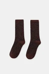 Calcetines de caña media con estampado de leopardo en tonos marrones y negros, confeccionados en tejido de algodón con acabado acanalado en el puño.