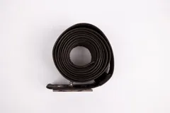 Cinturón largo de cuero marrón oscuro, enrollado en espiral, con hebilla metálica plateada de diseño simple y remache visible.