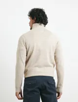 Sweater de punto color azul marino, con cuello alto, cierre frontal parcial y tapeta con botones. Presenta mangas raglán y puños y ruedo acanalados.